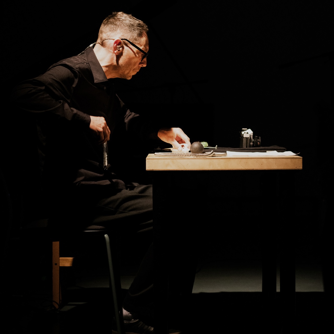 percussionist sitting at a table with various objects