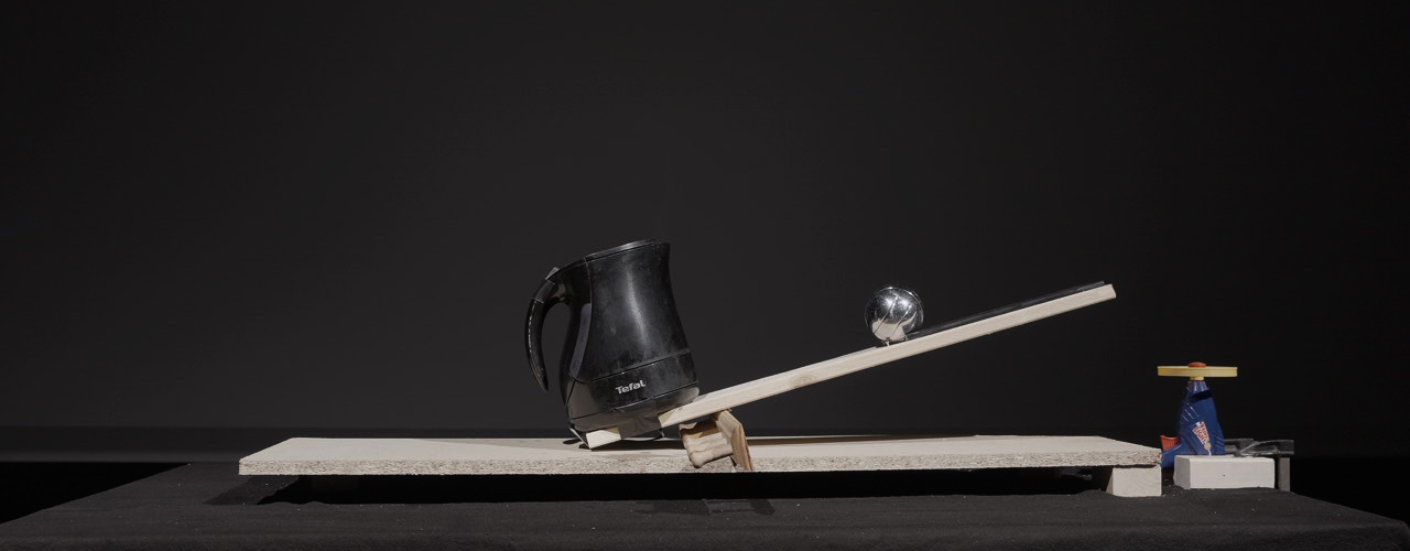 kettle and boule ball on a seesaw