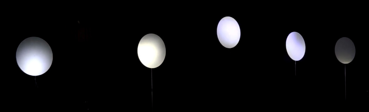 5 white discs in darkness